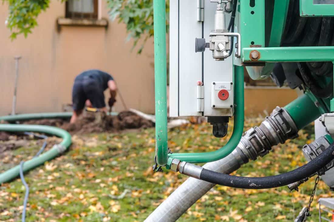 Outdoor septic system with man working in background